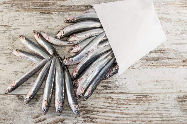 alici fresche su tavolo rustico in cartoccio